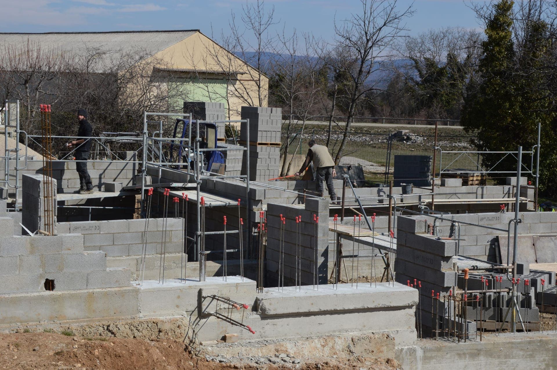Chantier de maçonnerie : ouvriers coulant une structure en béton